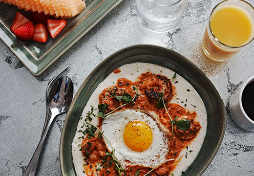 Egg dish with fruit, juice, water, and coffee